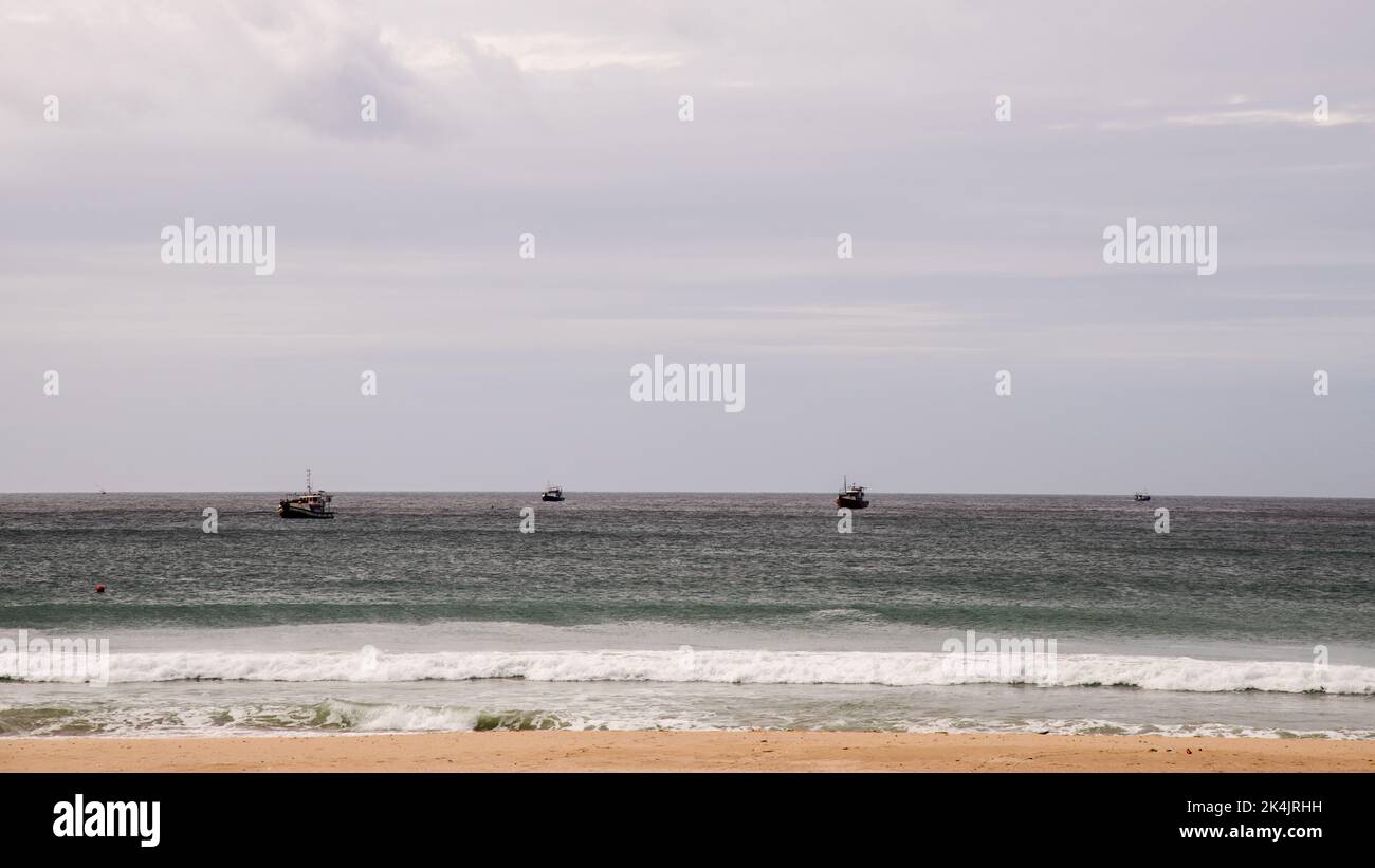 Splendido oceano multicolore con breakers, cielo blu con nuvole testurizzate e spiaggia di sabbia soffice Foto Stock