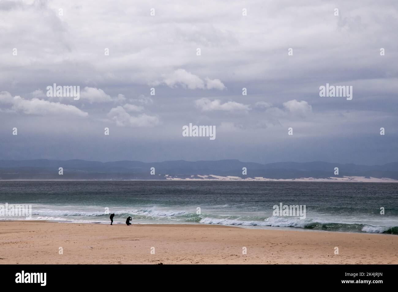 Splendido oceano multicolore con breakers, cielo blu con nuvole testurizzate e spiaggia di sabbia soffice Foto Stock