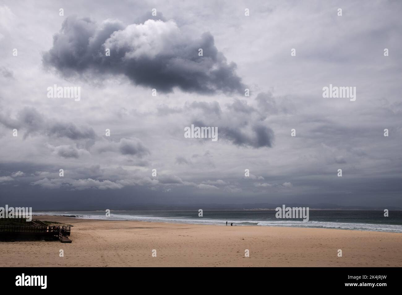 Splendido oceano multicolore con breakers, cielo blu con nuvole testurizzate e spiaggia di sabbia soffice Foto Stock