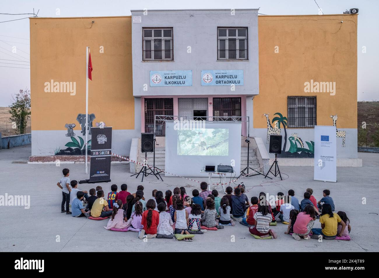 Batman, Turchia. 02nd Ott 2022. I bambini guardano attentamente il film animato nella loro lingua madre nel giardino della scuola. Batman Culture and Art Association organizza un evento cinematografico che introduce il cinema ai bambini che non hanno ancora conosciuto il cinema a Batman e nei villaggi dei suoi quartieri. L'associazione porta il film d'animazione di Hayao Miyazaki 'My Neighbor Totoro' nei villaggi come un doppiaggio curdo. (Foto di Bilal Seckin/SOPA Images/Sipa USA) Credit: Sipa USA/Alamy Live News Foto Stock