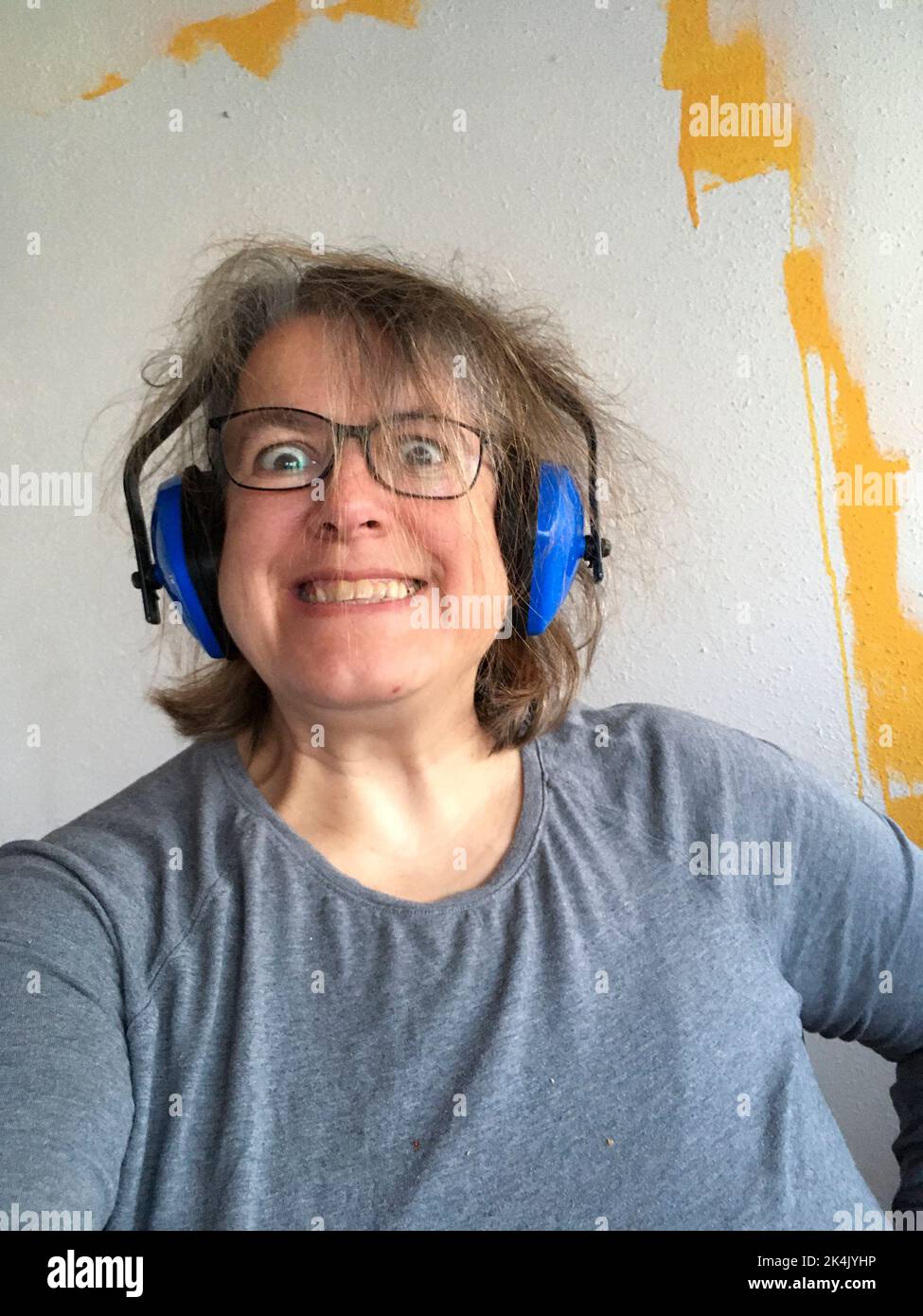 Frau mit Kopfhörer abstehenden Haaren, genervt vom Lärm Foto Stock
