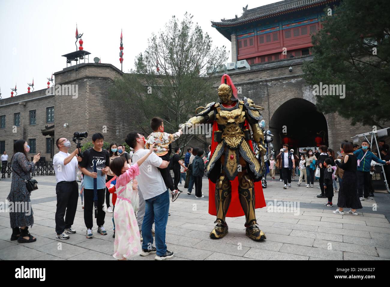 XI'AN, CINA - 1 OTTOBRE 2022 - i turisti posano con un 'Guerriero' di Mecha 2,7 metri di altezza navigando alla porta di Yongning del Muro della città di Xi'an a Xi'an, Shaanxi Foto Stock