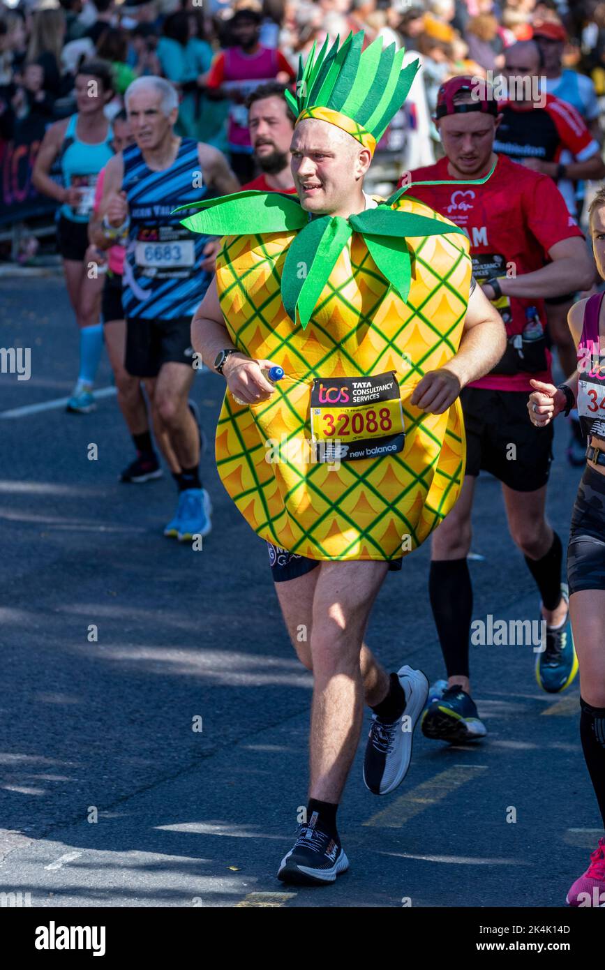 Simon Howard corre nella TCS London Marathon 2022, sulla Tower Hill Road, City of London, Regno Unito, indossando un costume di ananas Foto Stock