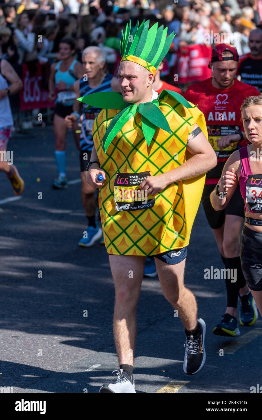 Simon Howard corre nella TCS London Marathon 2022, sulla Tower Hill Road, City of London, Regno Unito, indossando un costume di ananas Foto Stock