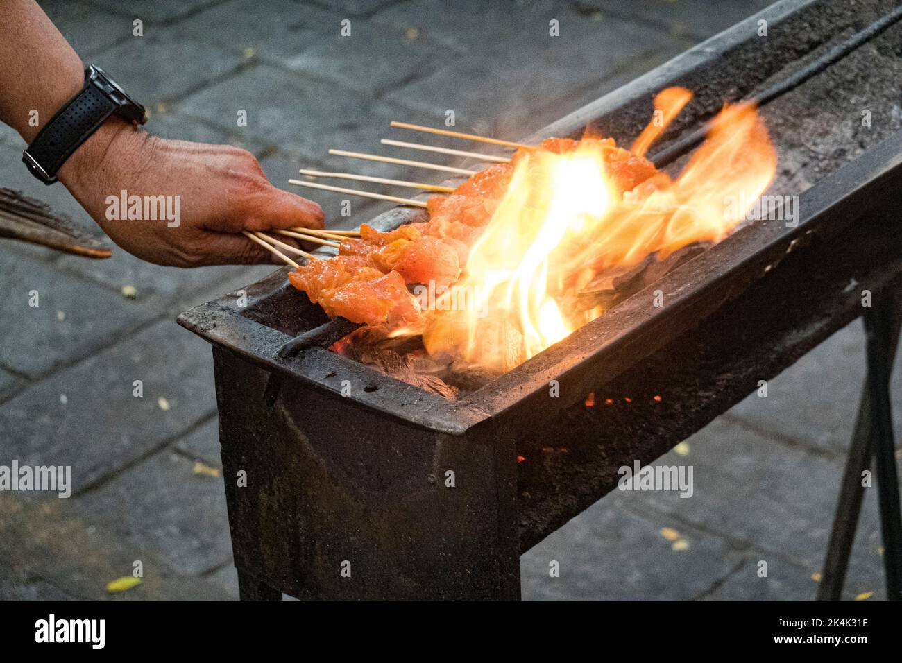Malesia, 10 luglio 2022 - spiedini di pollo cucinati su un fuoco aperto in un mercato notturno. Foto Stock