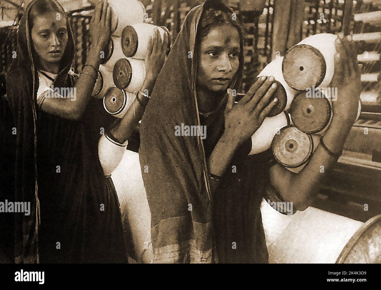 1940's (Post War) gli operai indiani trasportano le bobine in un mulino di cotone a Bombay (ora Mumbai). ---- ۱۹۴۰ کی دہائی (جنگ کے بعد) بمبئی (اب ممبئی) کی ایک کاٹن مل میں ہندوستانی مزدور بوبن لے کر جا رہے ہیں۔ ------- 1940 के दशक (युद्ध के बाद) भारतीय श्रमिक बॉम्बे (अब मुंबई) में एक कपास मिल में बोबिन ले जाते हैं। Foto Stock