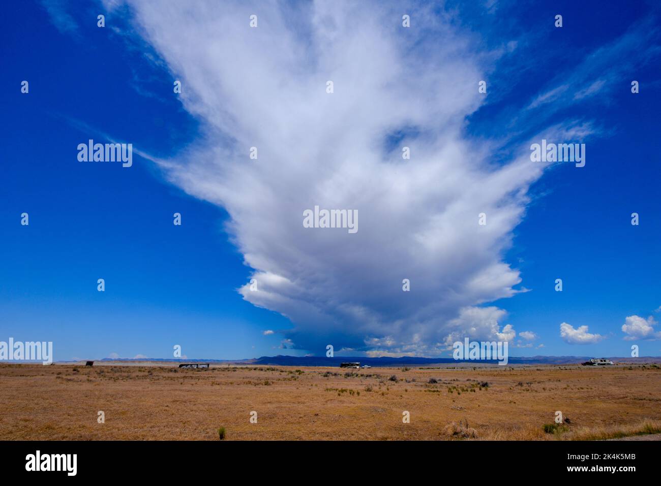 Un'enorme nuvola di tempesta sulle colline del Colorado vista dal deserto vicino al confine dello Utah negli Stati Uniti Foto Stock