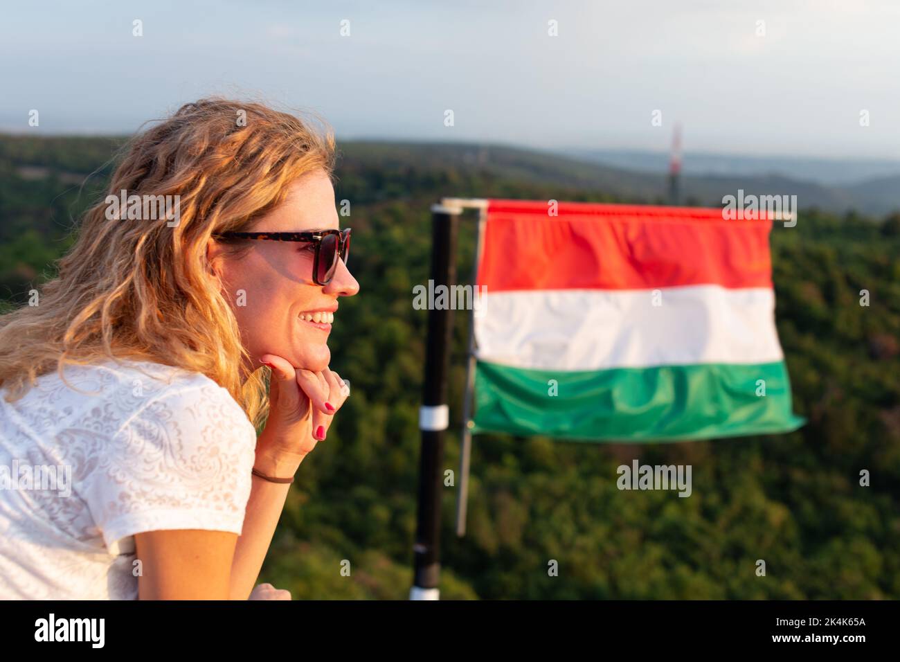 Giovane donna caucasica allegra rilassarsi nella natura a bandiera ungherese, vista profilo, Ungheria Foto Stock