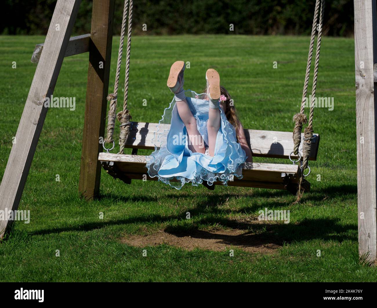 Ragazza giovane su un sedile di oscillazione, Regno Unito Foto Stock