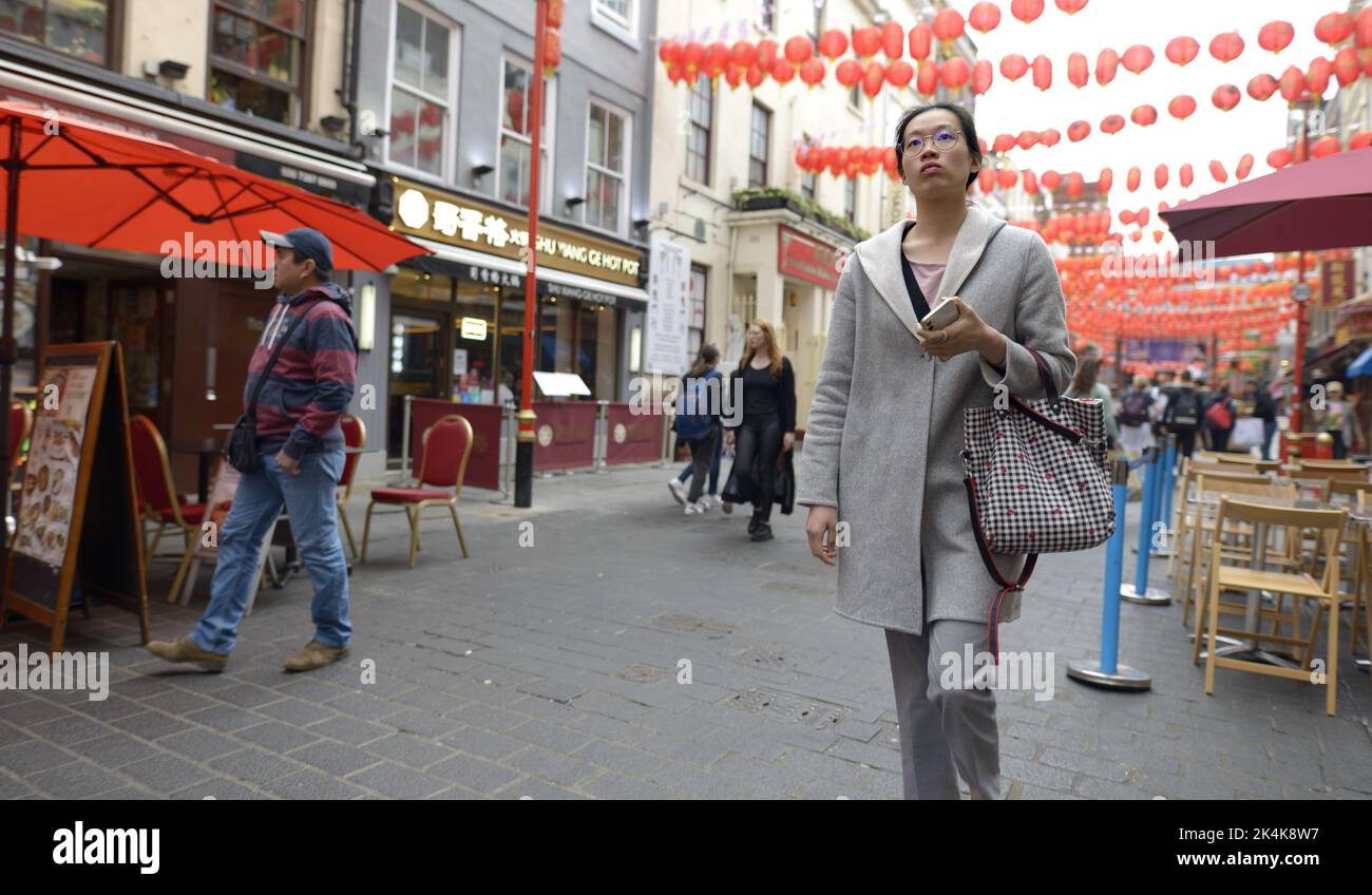 Londra, Inghilterra, Regno Unito. Giovane donna cinese che cammina a Chinatown Foto Stock