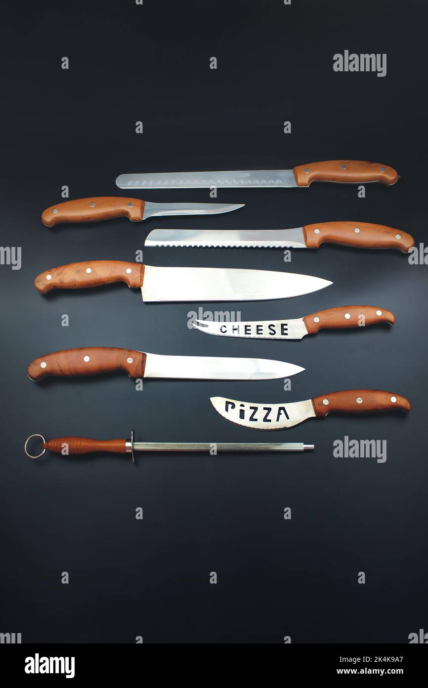 Coltelli da cucina diversi a su superficie nera. Include coltelli da intaglio, da parare e da utilità Foto Stock