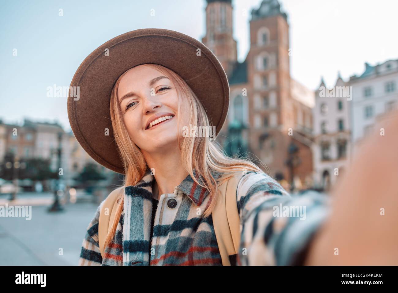 Felice donna bionda glamour in cappello marrone che fa selfie nel centro storico di Cracovia. Polonia Europa Foto Stock