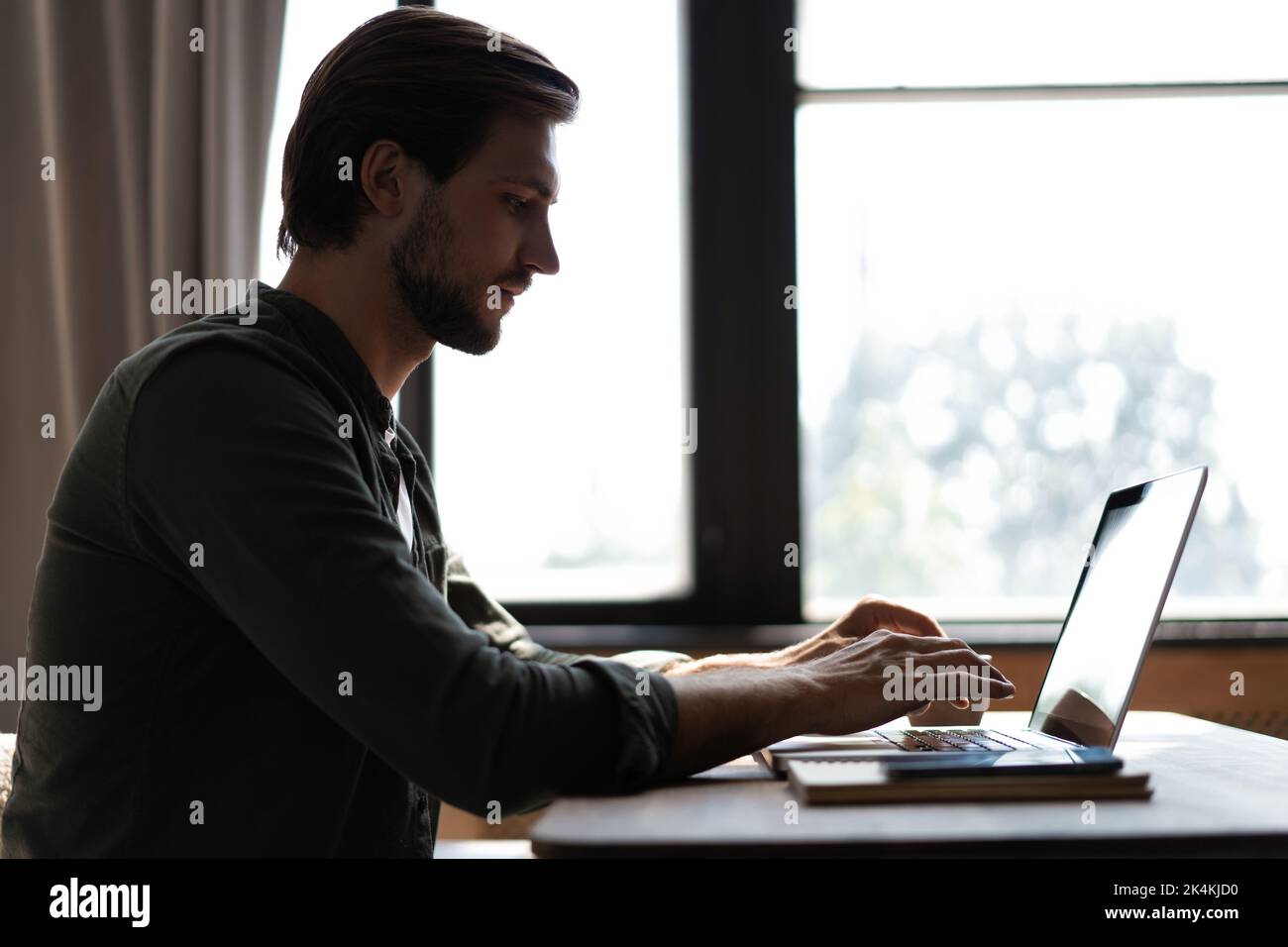 Maschio telelavoro da casa e con videochiamata di confrence di lavoro. Freelance che lavora su un computer portatile in ufficio Foto Stock