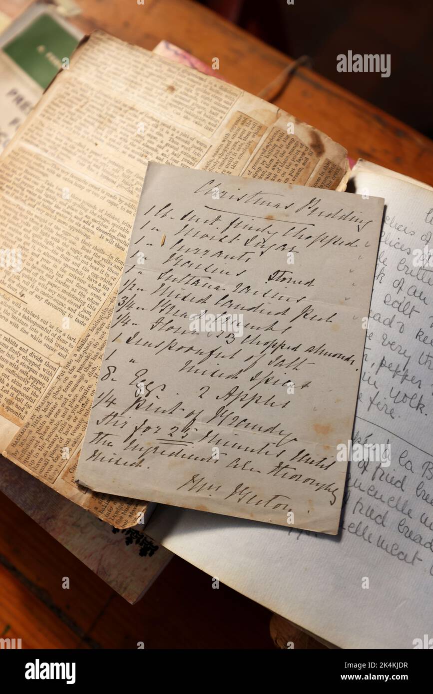 Libri in vecchio stile e una lente d'ingrandimento che mostrano la scrittura a mano del passato al Weald & Downland Museum, Chichester, West Sussex, Regno Unito. Foto Stock