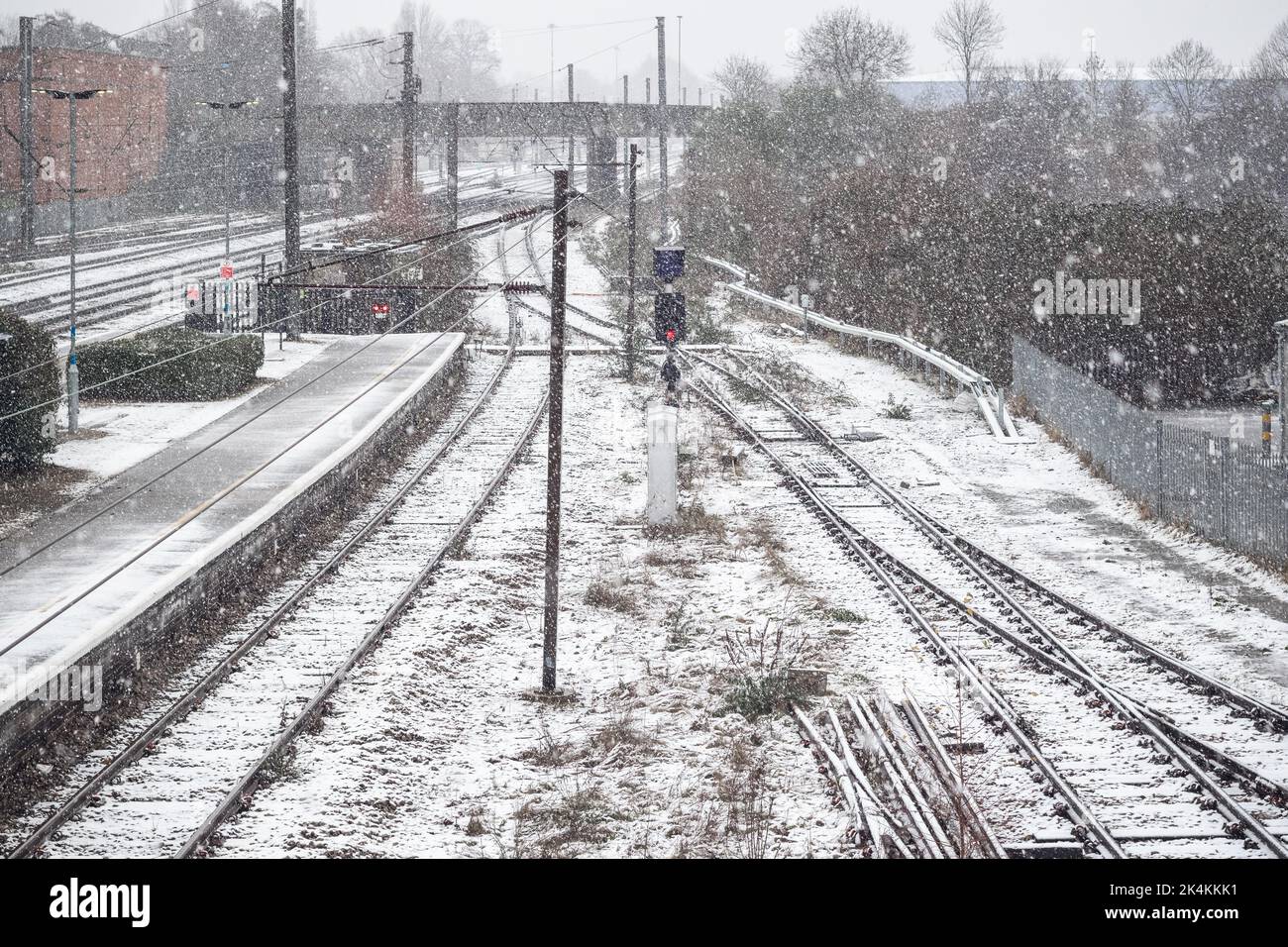 Binari ferroviari coperti di neve invernale alla stazione ferroviaria di Welwyn Garden City, Regno Unito Foto Stock