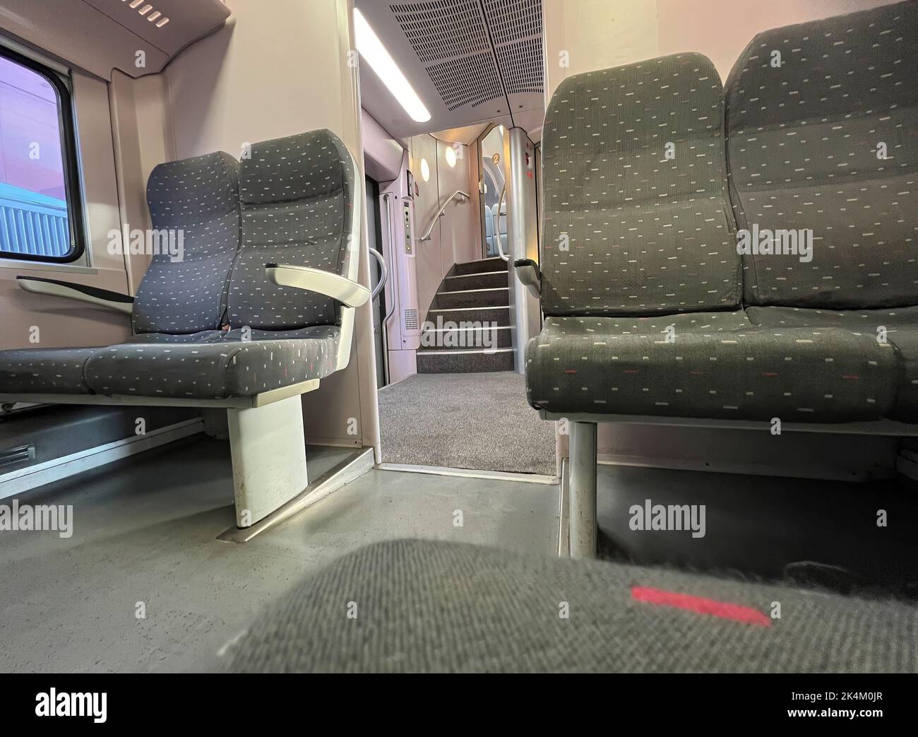 Vista interna su un vagone ferroviario belga a due piani vuoto e grigio fino alla capitale Bruxelles con scale Foto Stock