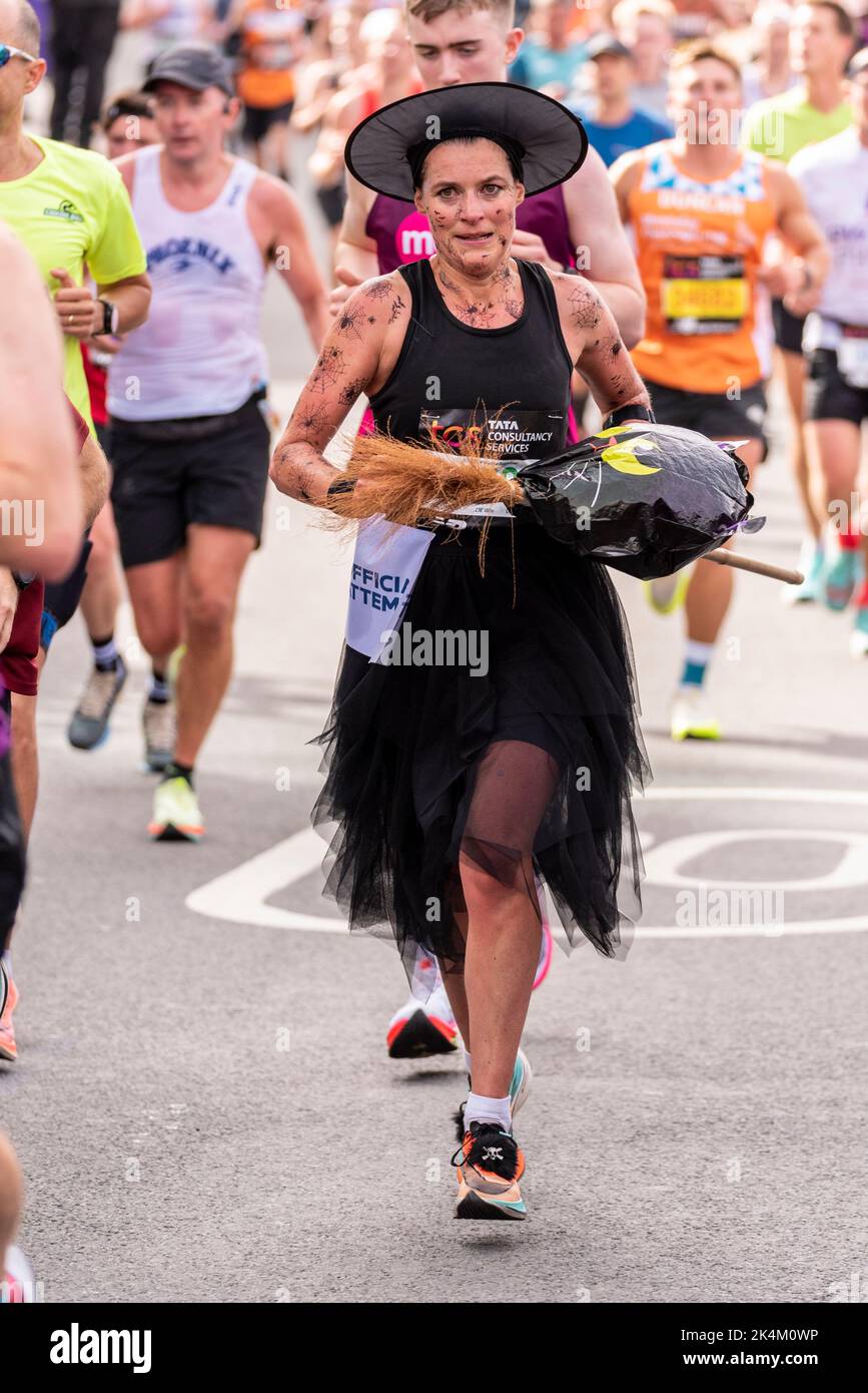 Sarah Dudgeon in esecuzione nel TCS London Marathon 2022, sulla strada di avvicinamento Tower Bridge, City of London, UK. Tentativo di registrazione ufficiale in costume streghe Foto Stock