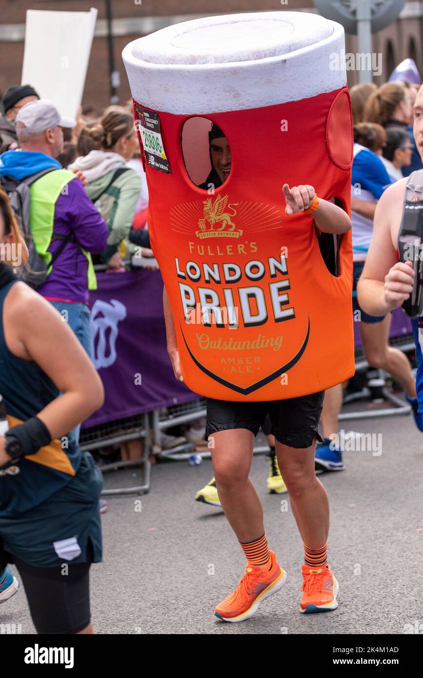 Alejandro Oostlander in esecuzione nella TCS London Marathon 2022, sulla strada di avvicinamento Tower Bridge, City of London, UK, indossando il vetro della pinta di birra Pride di Londra Foto Stock