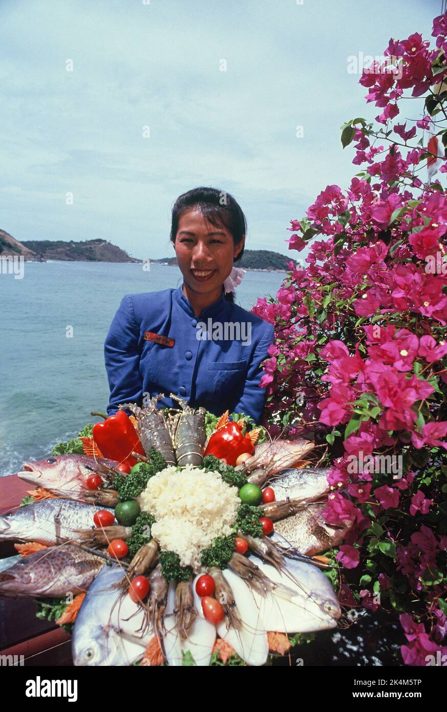 Thailandia. Phuket Yacht Club. Giovane donna tailandese con vassoio di frutti di mare in mostra. Foto Stock