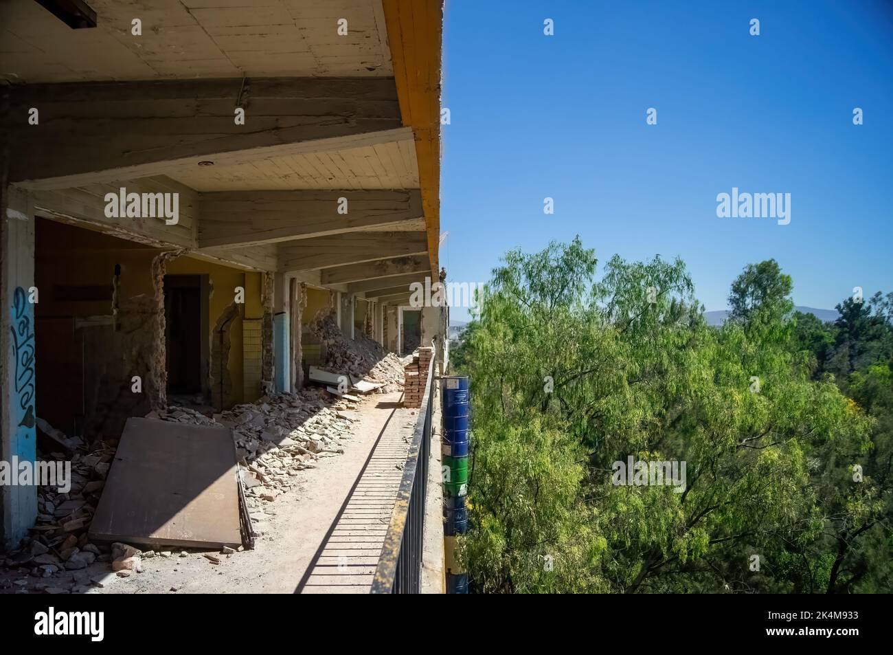 demolizione di muri, in un edificio si può vedere metà della costruzione e gli alberi e cielo. pareti e tetti in cemento Foto Stock
