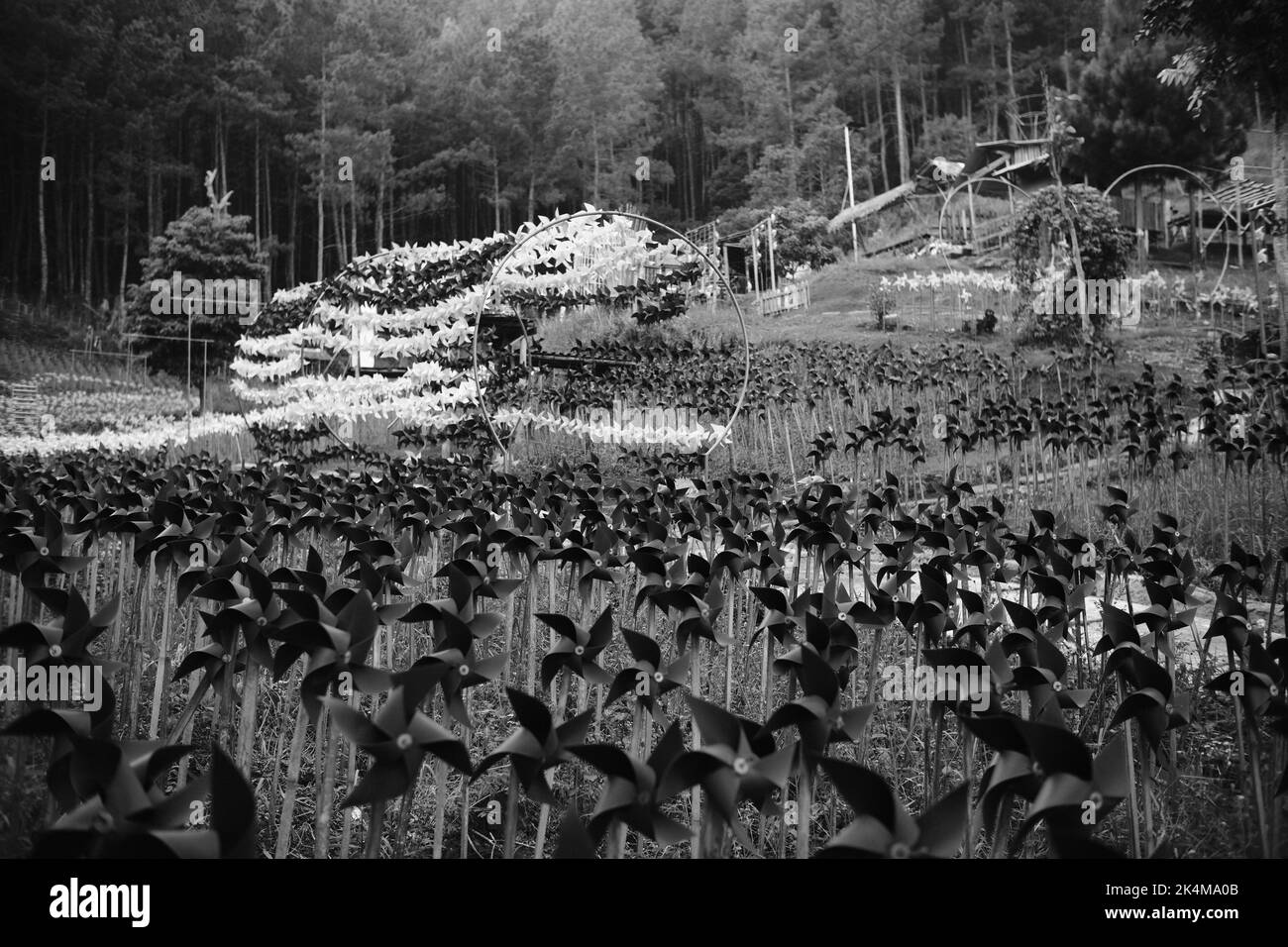 Foto monocromatica di un parco giochi pieno di migliaia di decorazioni fatte a mano ruota panoramica nella zona di Cikancung - Indonesia Foto Stock