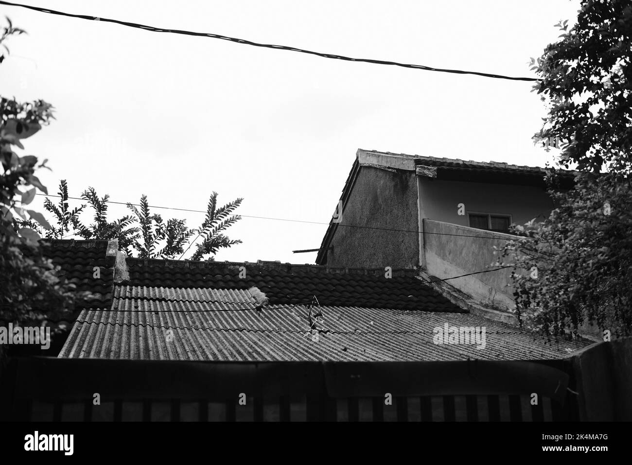 Foto monocromatica del tetto di una casa quando il tempo è nuvoloso nella zona di Cikancung - Indonesia Foto Stock