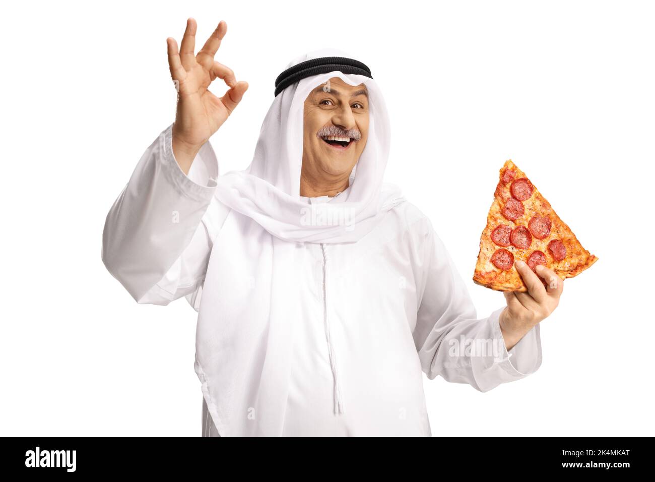 Uomo arabo maturo in abiti etnici che tiene una fetta di pizza peperoni e gesture buon segno isolato su sfondo bianco Foto Stock