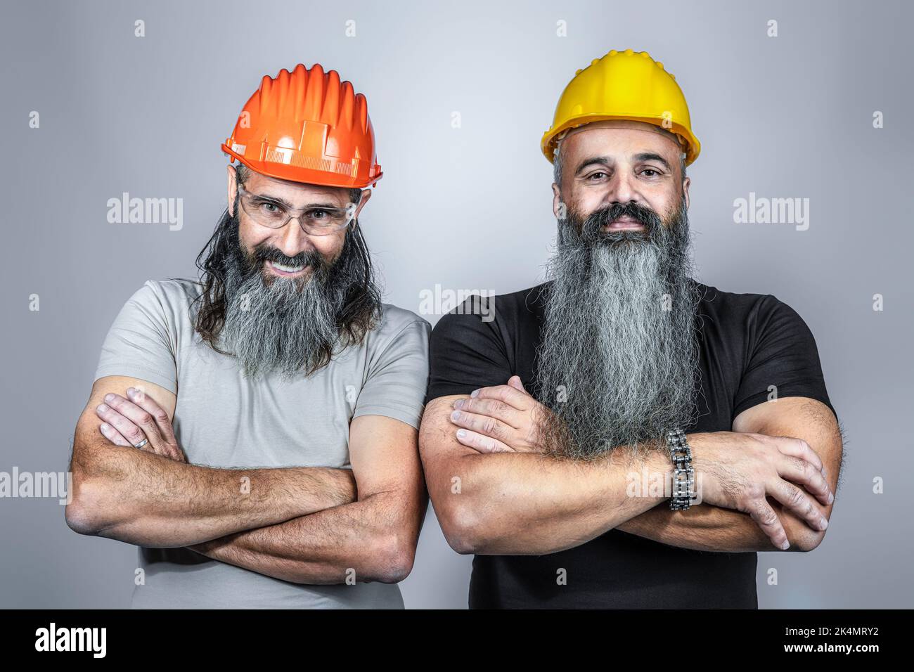 handymans con elmetto e braccia incrociate, lunghe barbe, studio shot Foto Stock