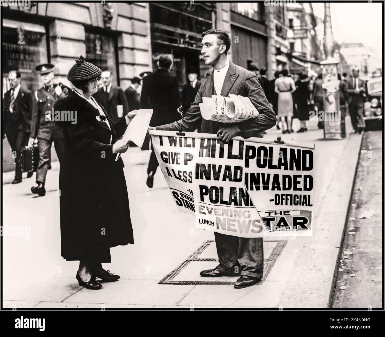 WW2 invasione della Polonia giornale Venditore titoli Donna acquistare un giornale con i titoli della Germania nazista invasione della Polonia. Settembre 1, 1939. Foto Stock