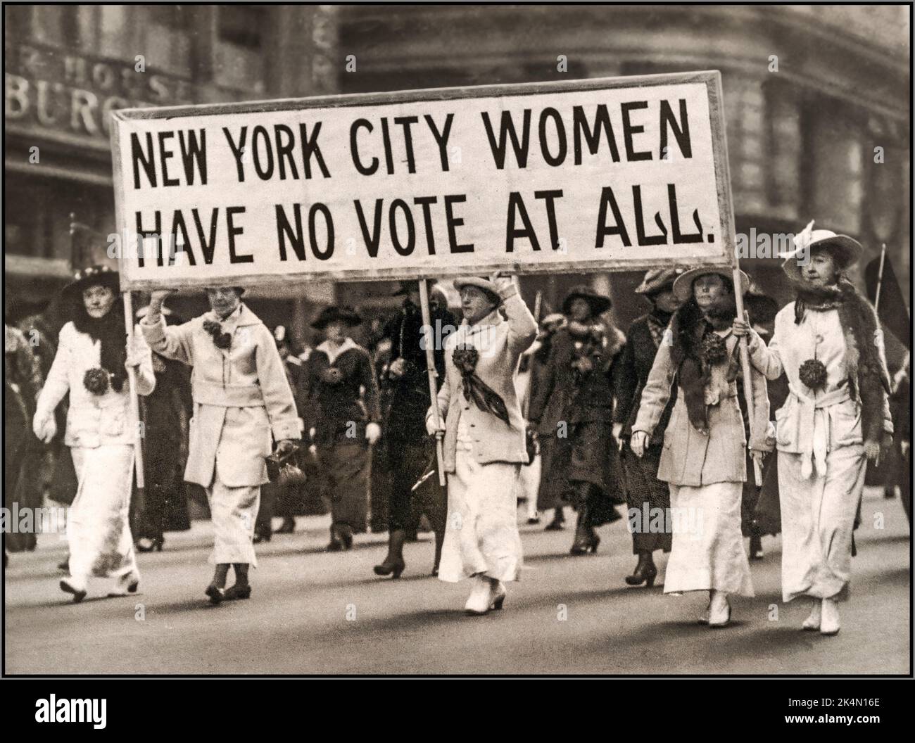 1900s suffragio per le donne a New York City 'NEW YORK CITY HAVE NO VOTING AT AFFATTO' dimostrazione con banner su New York Streets. Un appello per una modifica del 19th alla situazione americana. New York, Stati Uniti Foto Stock