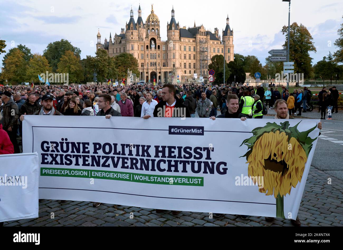 Schwerin, Germania. 03rd Ott 2022. Una manifestazione contro la politica energetica inizia di fronte al castello di Schwerin, un banner recita: "La politica verde significa distruzione dell'esistenza”. Secondo le autorità di assemblaggio, in diverse città sono previste manifestazioni contro il forte aumento dei prezzi dell'elettricità e del gas e le conseguenze dell'inflazione. Credit: Bernd Wüstneck/dpa/Alamy Live News Foto Stock