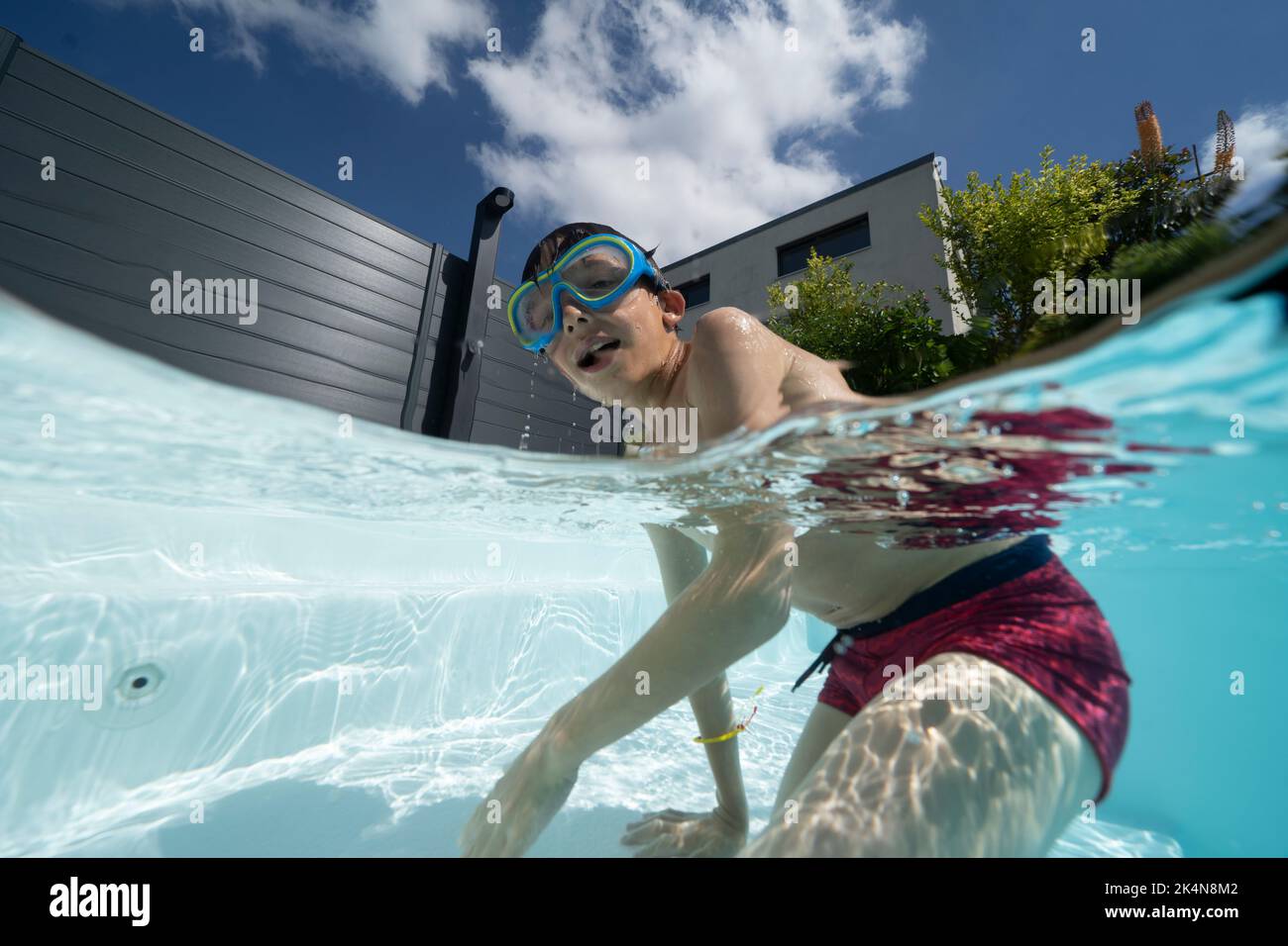 Giovane ragazzo giocando in una piscina Foto Stock