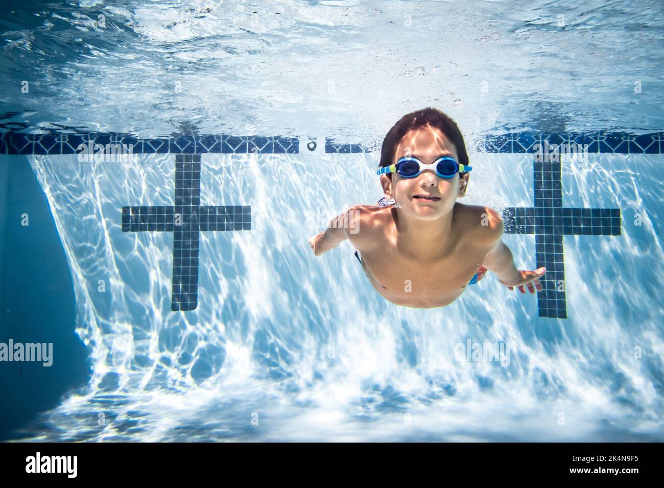 Fotografia subacquea del ragazzo con occhiali in piscina. Foto Stock