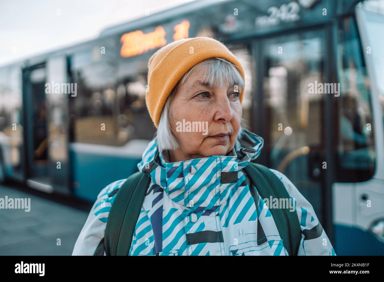 Donna anziana alla fermata dell'autobus all'aperto in città o in città Foto Stock