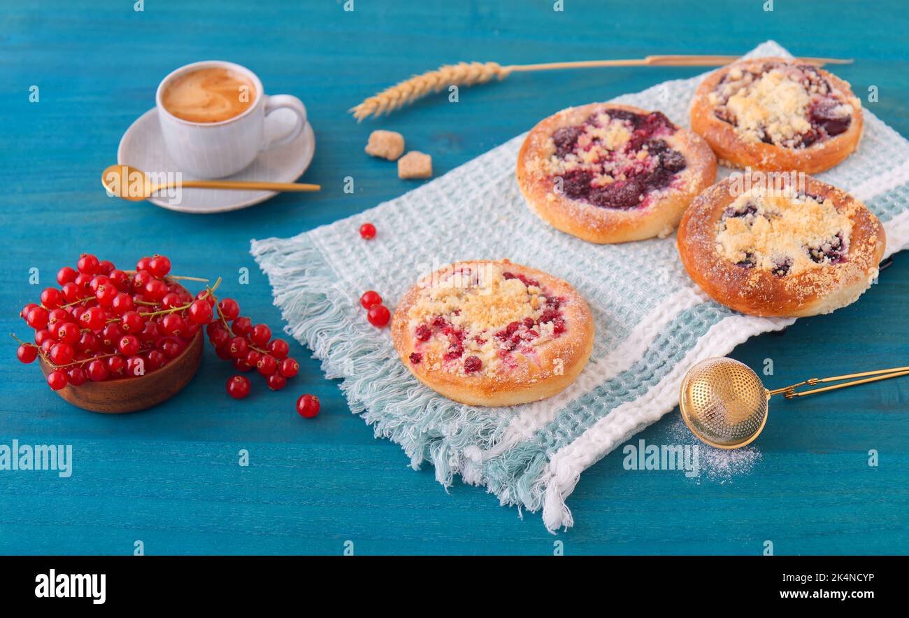 Torte al forno con frutta estiva, ribes, prugne, more, mirtilli e sbriciolarsi su un tavolo di legno blu, angolo di visione alto, nessuna gente. Foto Stock