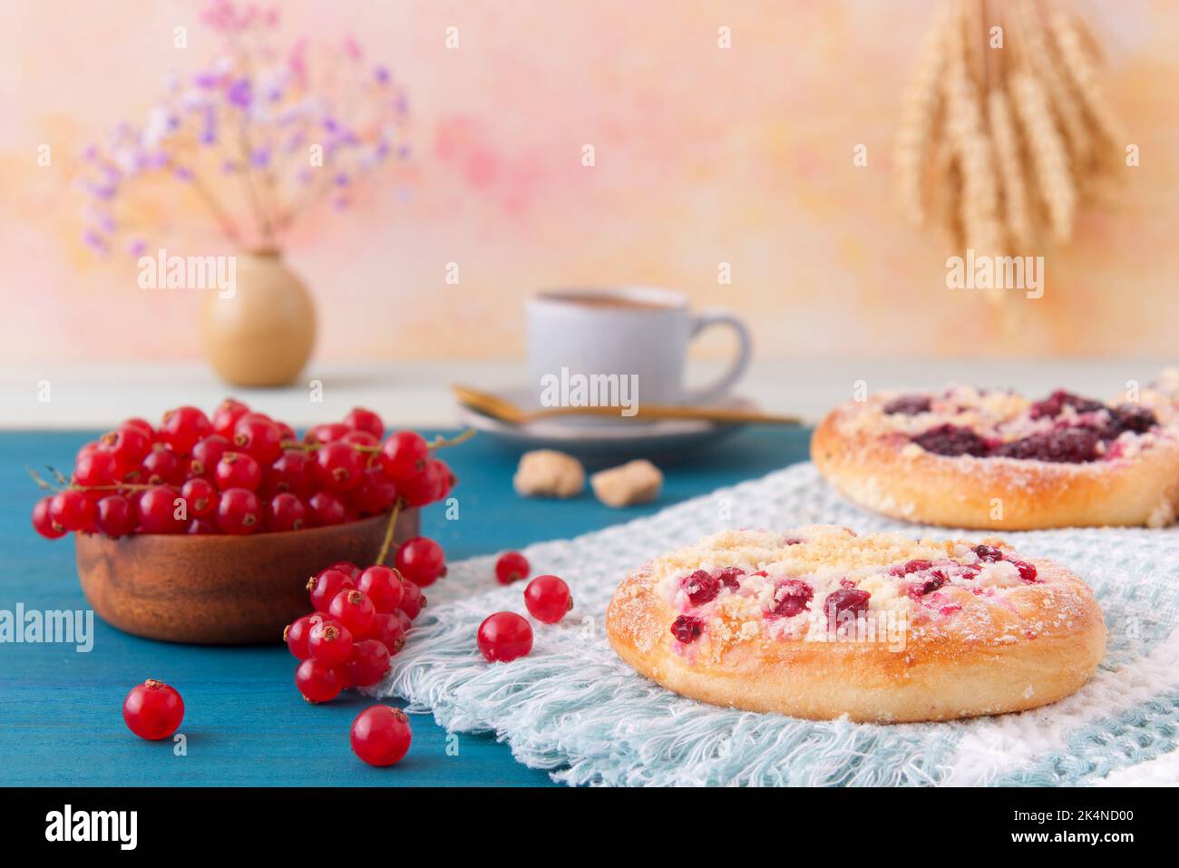 Primo piano di torte farcite di frutti estivi, ribes, prugne, more, mirtilli e crumble, tavolo di legno blu, angolo di visione basso, nessuna persona. Foto Stock