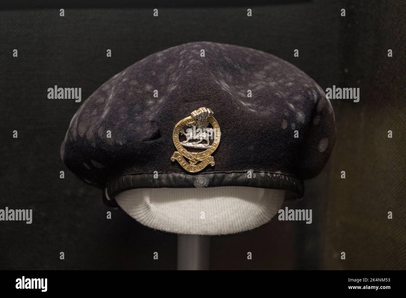 Un berretto e un badge di berretto (si noti il logo piegato colpito da un proiettile in una rivolta di Belfast) in mostra a dover Castle, Kent, Regno Unito. Foto Stock