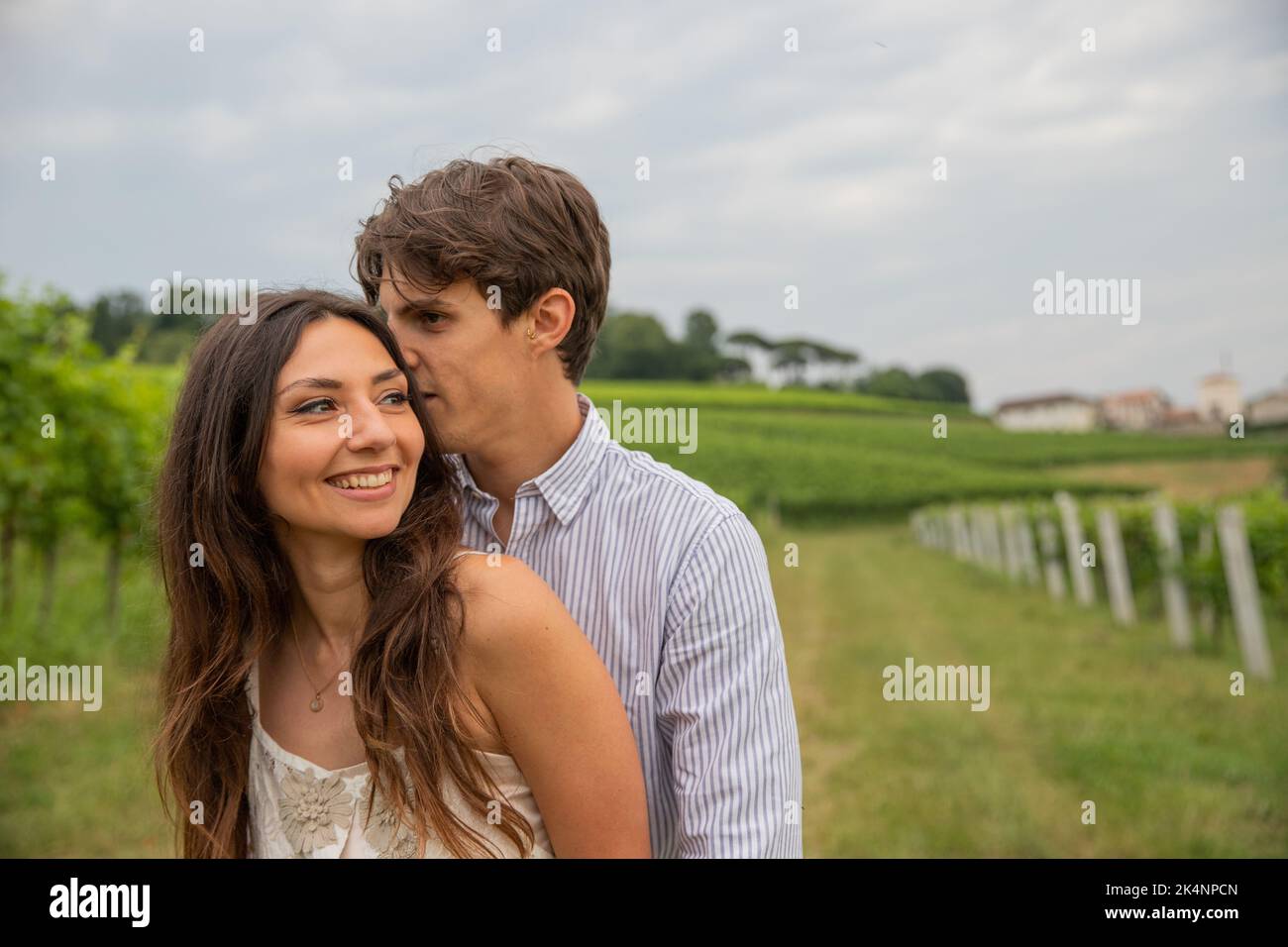 Durante la romantica passeggiata in vigna, il ragazzo sussurra le parole al suo amante e ascolta divertito. Foto Stock