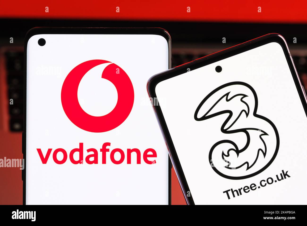 Vodafone e tre potenziali concetti di fusione. Gli smartphone visualizzati insieme ai logo degli operatori mobili del Regno Unito sulle schermate. Stafford, Regno Unito, Oc Foto Stock