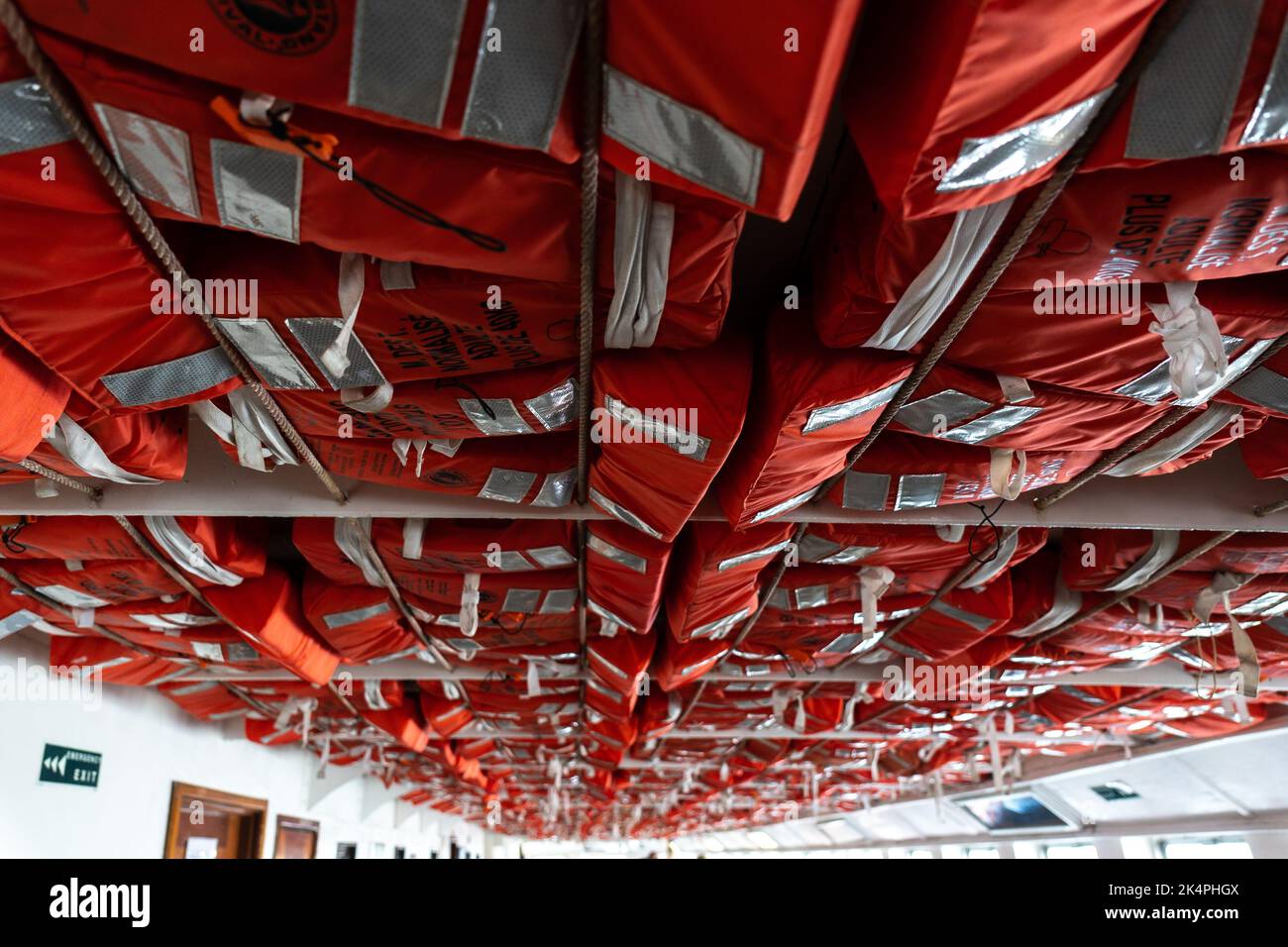 Toronto, Canada - Maggio 28 2022: Giubbotto di salvataggio dei passeggeri arancione immagazzinato sul ponte principale di un soffitto per motivi di sicurezza Foto Stock