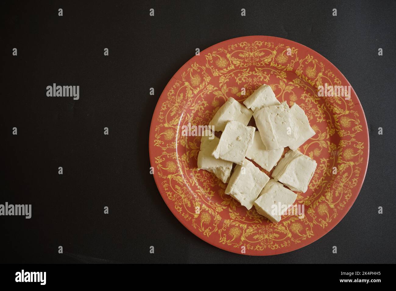 Formaggio tofu in piatto colorato su sfondo nero con spazio copia per il testo. Concetto di cibo sano Foto Stock