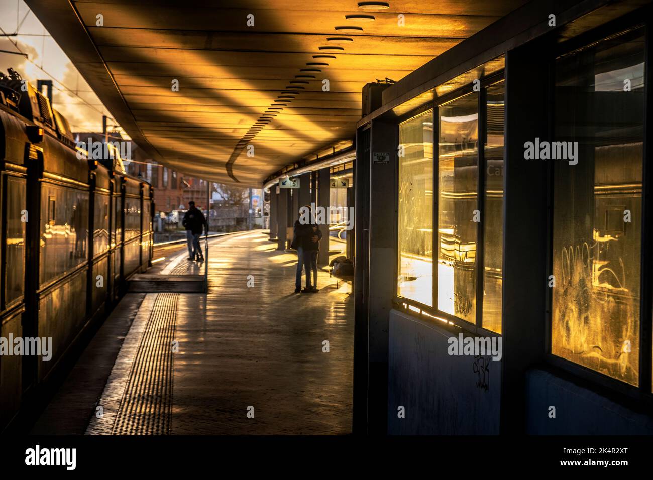 Una coppia che si bacia in serata bagliore su una piattaforma ferroviaria a Lisbona, Portogallo Foto Stock