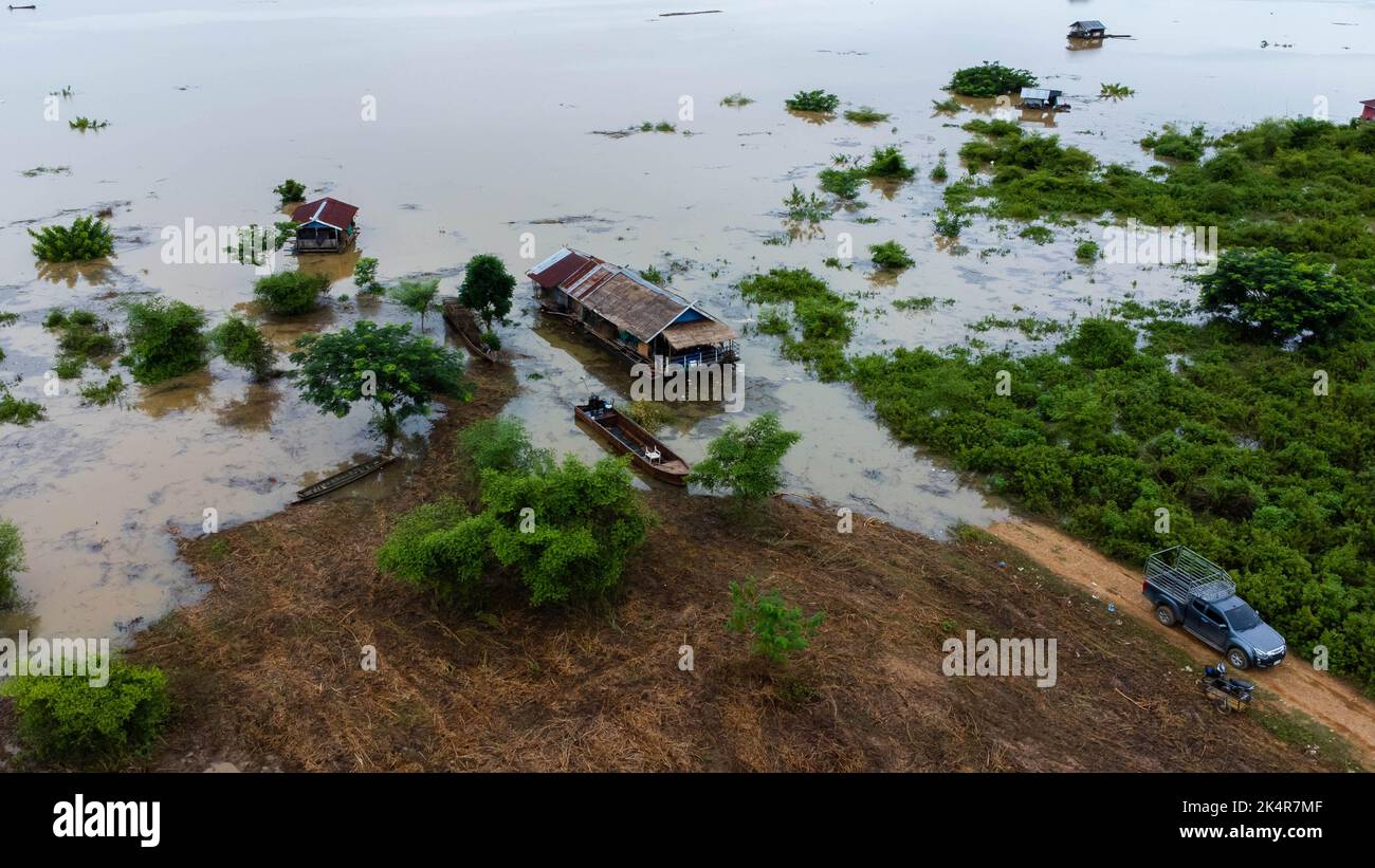 La vista aerea delle barche a coda lunga in un prato verde è influenzata dalle inondazioni nella stagione delle piogge. Vista dall'alto del fiume che scorre dopo forti piogge e inondazioni Foto Stock