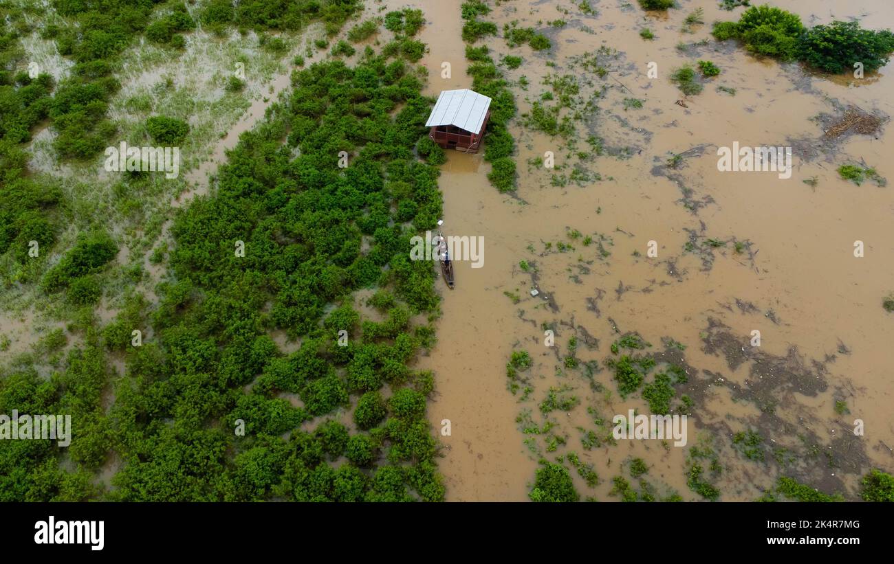 La vista aerea di una barca a coda lunga in un prato verde è influenzata dalle inondazioni nella stagione delle piogge. Vista dall'alto del fiume che scorre dopo la pioggia e l'alluvione Foto Stock