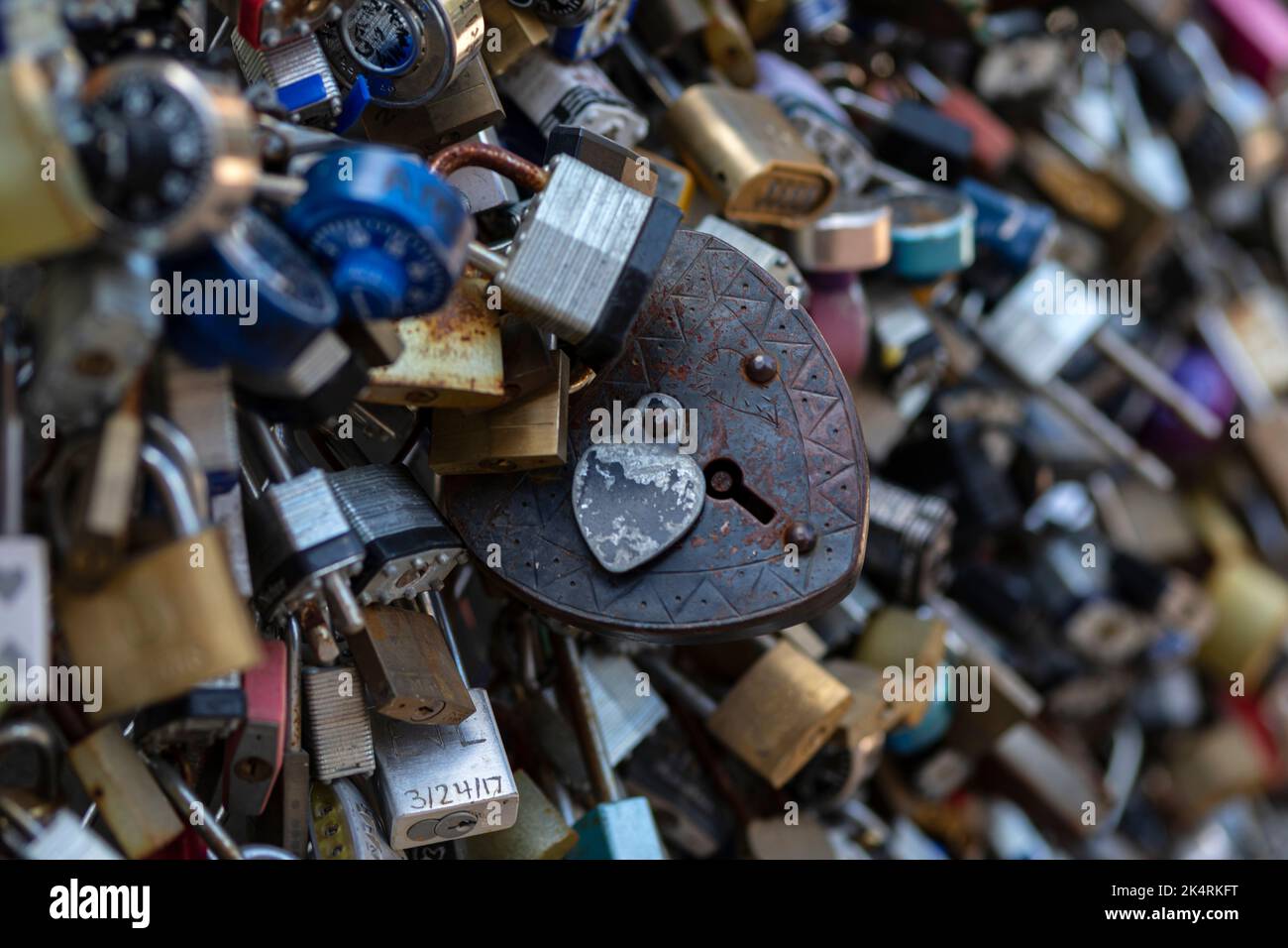 Lucchetti vecchi e nuovi con nomi e date scritte su di essi si bloccano su un ponte come segno d'amore a San Antonio, Texas. Foto Stock