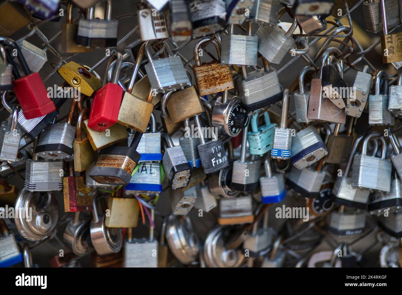 Lucchetti vecchi e nuovi con nomi e date scritte su di essi si bloccano su un ponte come segno d'amore a San Antonio, Texas. Foto Stock