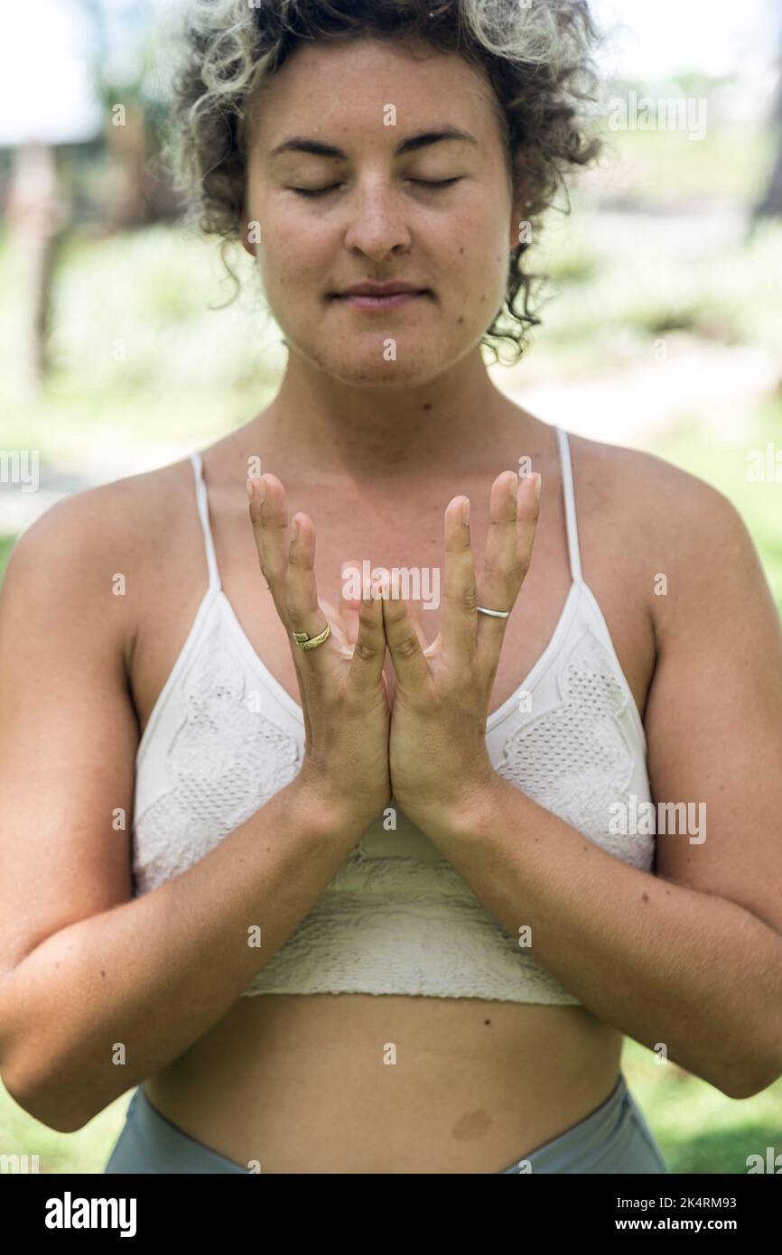 Donna caucasica in abbigliamento sportivo che fa yoga posa in natura. Yoga all'aperto Foto Stock