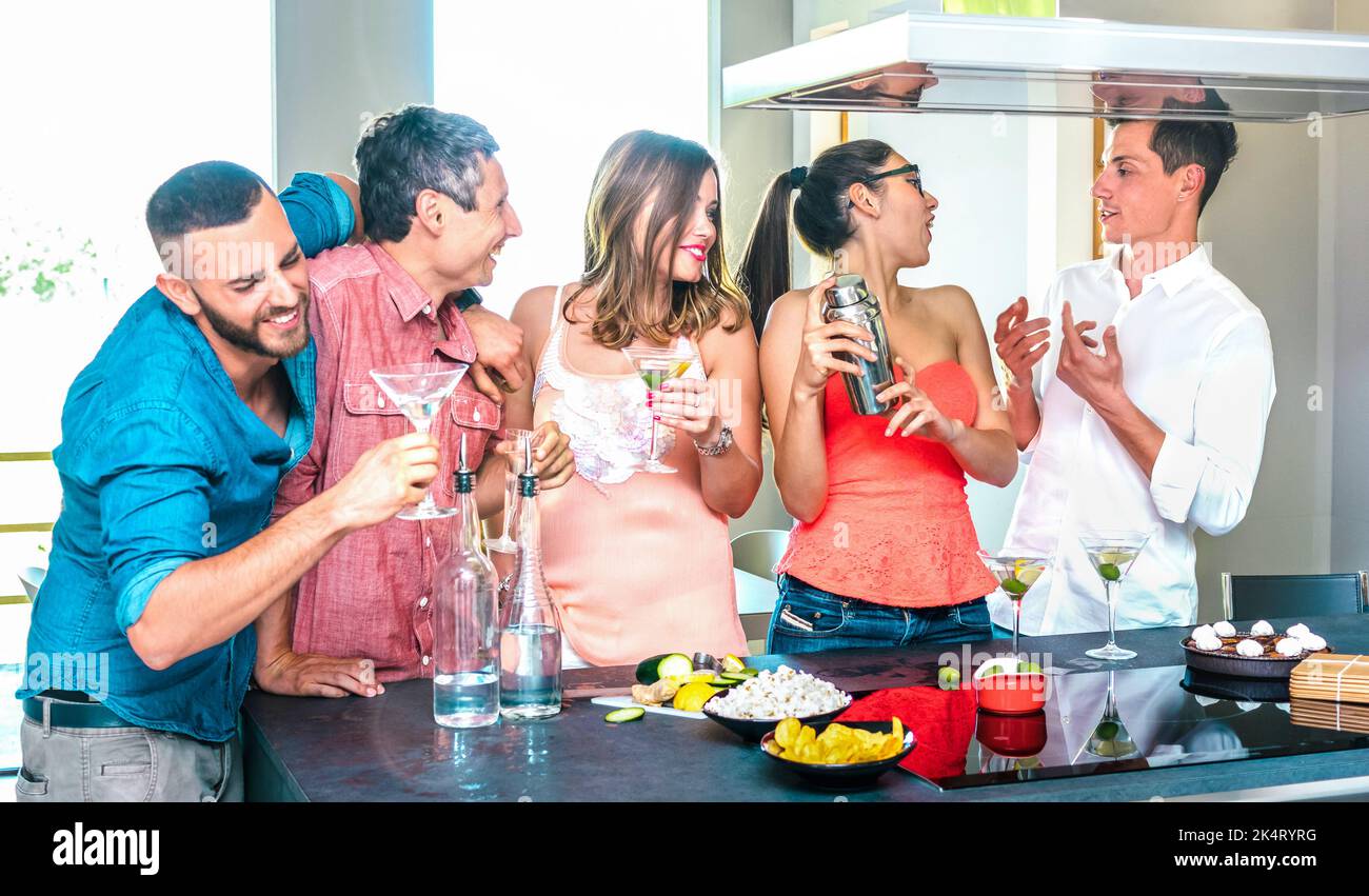Gruppo di amici che si diverte al cocktail bar della casa con aperitivo prima di cena durante l'happy hour - giovani milleniali che trascorrono del tempo insieme a casa ecc Foto Stock