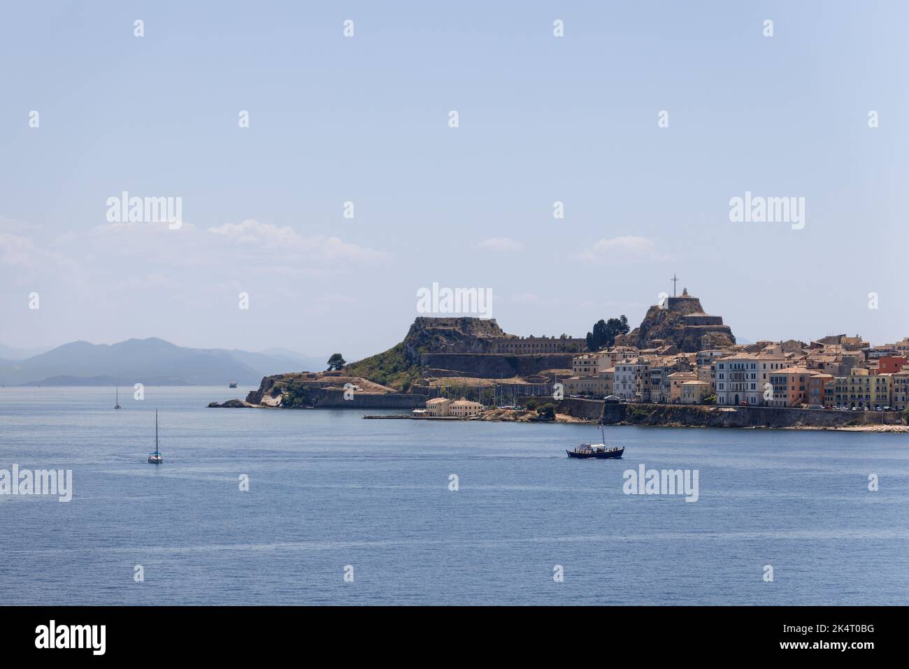 Piccole barche a vela e a motore sul mare increspato nel porto della città di Corfù sullo sfondo della Fortezza Vecchia, Kerkira, isole ioniche Foto Stock
