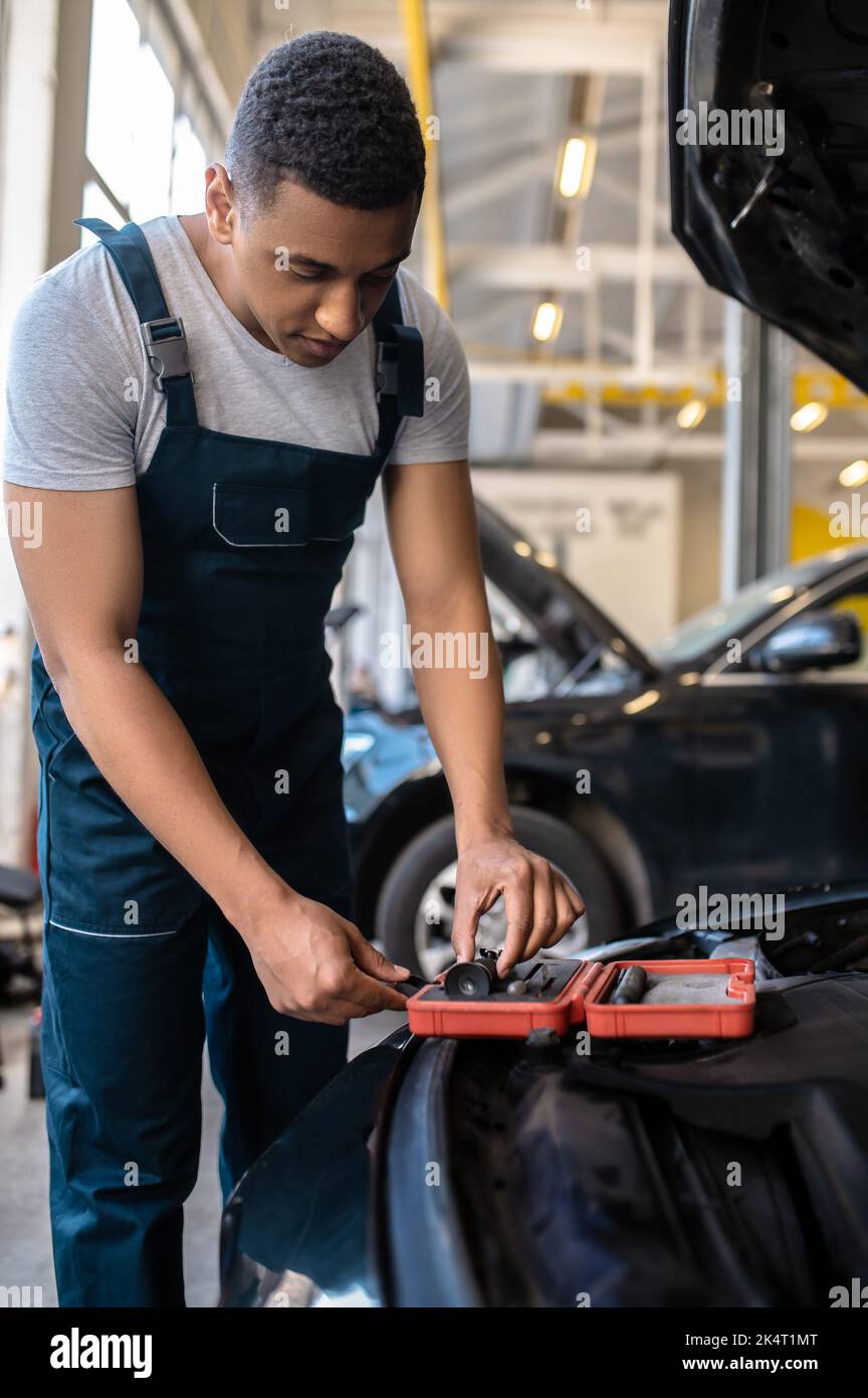 Un tecnico specializzato nella scelta di uno strumento ottico per il lavoro Foto Stock